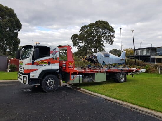 Towing a breakdown vehicle with Buchan Towing's tilt-tray truck