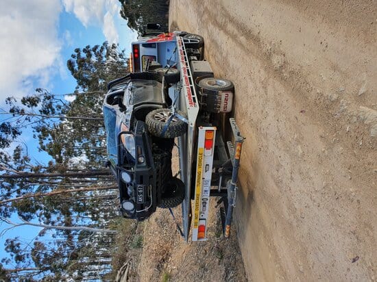 a crashed pick up being towed in a truck