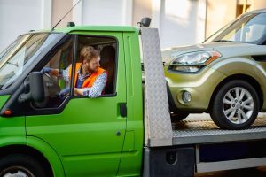 In a green truck, a person who is professional in vehicle towing